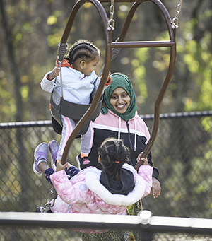 Woman and two children on a swing.