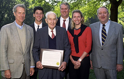 Six members of the Eakin Family with LeRoy Eakin holding a plaque.
