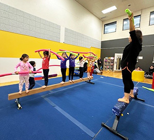 Instructor Ms Jae leads children's gymnastics.