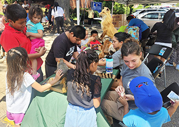 People at table outside learning about nature.