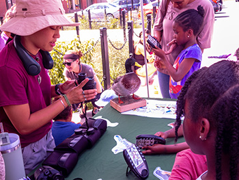 Girl with binoculars teaching children.