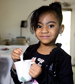 Girl holding cup.
