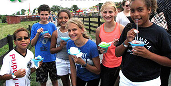Children enjoy ice cream treats at fair.