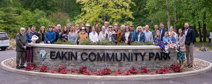 Members of the Eakin Family stand behind the new stone entry to Eakin Community Park.